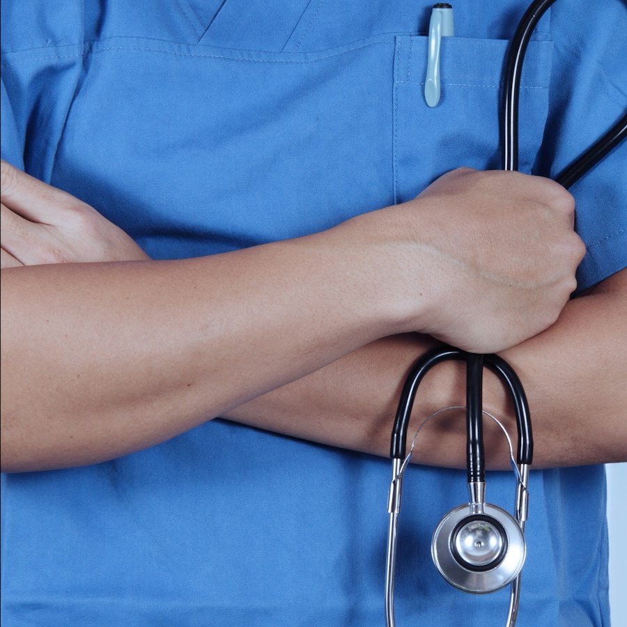 Physician in blue scrubs holding a stethoscope